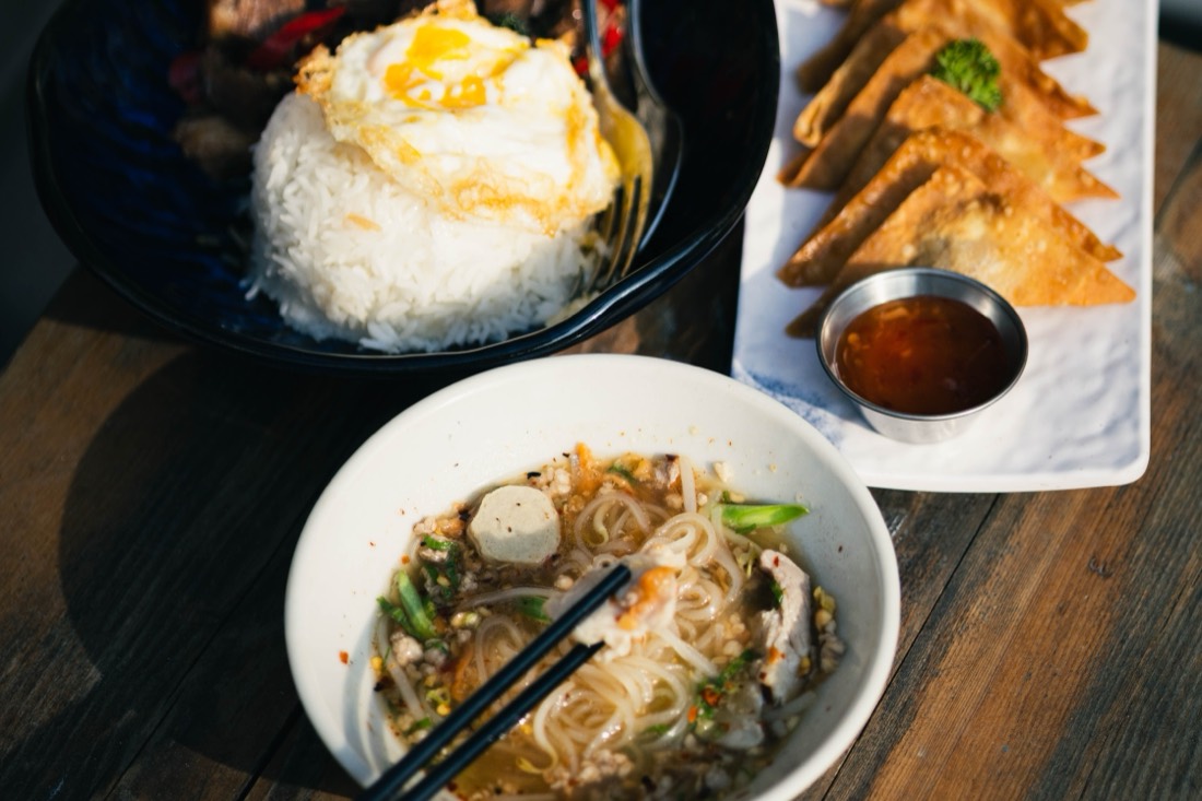 A shared table of noodle bowls and side dishes at Teow Tem Toh